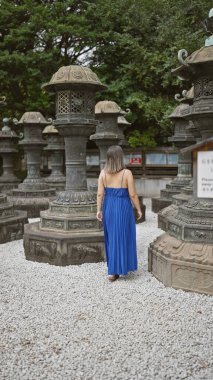 Gözlüklü güzel bir İspanyol kadının büyüleyici görüntüsü, Ueno Park 'ın ünlü tapınağından uzaklaşırken yakalanmış, esmer saçları her adımda zıplıyor..