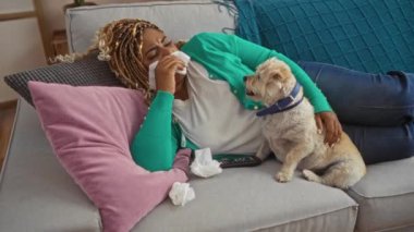 Saçları örgülü genç bir Afro-Amerikalı kadın, bir köpekle kanepede uzanıyor, hüzünlü bir film izliyor, evinde rahat bir oturma odasında mendille gözyaşlarını siliyor..