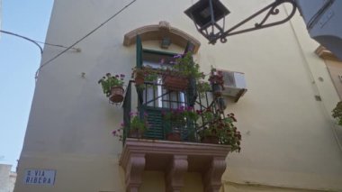 Gündüz vakti Ribera boyunca Gelibolu, Puglia, İtalya ve Avrupa 'nın pitoresk açık hava ortamında canlı çiçeklerle dolu büyüleyici bir balkon..