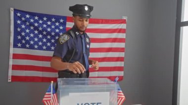 Afrika kökenli Amerikalı polis memuru önemli bir Amerikan bayrağıyla bir seçim bölgesini izliyor..