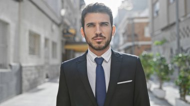 Yakışıklı, takım elbiseli adam bulanık bir geçmişi olan bir şehir caddesinde güvenle duruyor..