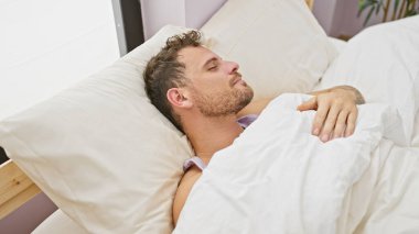 Sakallı yakışıklı genç adam yatak odasında huzur içinde uyuyor..