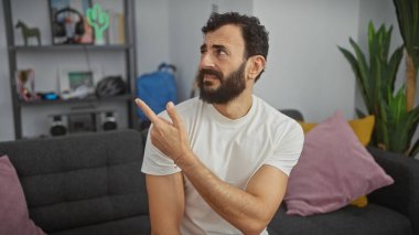 Sakallı adam modern oturma odası düzeninde şaşırmış ve bakıyor..