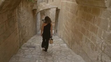 İtalya 'nın Basilicata kentindeki eski caddelerin dar taştan geçitlerini keşfeden genç bir kadın, tarihi Avrupa sokaklarının özünü ve cazibesini yakalıyor..