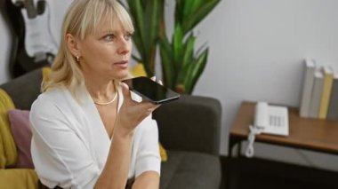 Beyaz kadın evde akıllı telefon kullanıyor, iletişim ve modern yaşam tarzı gösteriyor.