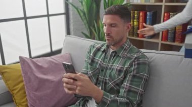 Şaşırmış bir adam ve yeteneği olan bir kadın kanepede oyun dolu bir anı yaşıyorlar..