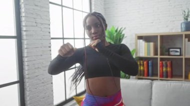 Örgü ören Afrika kökenli Amerikalı kadın, ev ortamında spor yapıyor, spor yapıyor, güzellik ve sağlıklı yaşam tarzını sergiliyor..