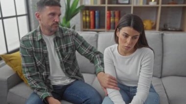 Sevgi dolu İspanyol bir çift, aile desteğini ve birlikteliği tasvir eden, rahat oturma odalarındaki kanepede birbirlerini rahatlatıyorlar..