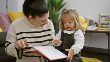 Anne ve kızı, sıcak bir oturma odasında aile, aşk ve öğrenme üzerine kitap yazıyorlar..