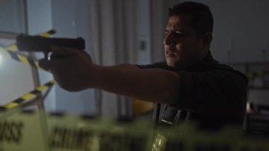İspanyol dedektif loş aydınlatılmış suç mahalli dairesine tabanca doğrultuyor.