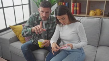 Bir erkek ve bir kadın, evdeki iç dizayn sürecini gösteren bir kanepede renk örneklerini birlikte inceliyor.