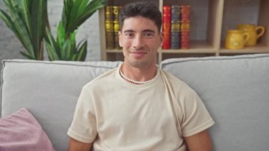 Kırmızı bir kalp sembolü taşıyan gülümseyen genç bir İspanyol. Kapalı bir koltukta oturmuş, aşk ve mutluluğu iletiyor..