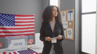 Bir kadın ve bir erkek, Amerikan bayraklarıyla ABD oy kullanma merkezinde oylama yapıyorlar.