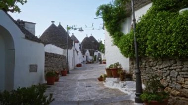 Alberobello, Puglia 'da büyüleyici bir sokak. Geleneksel trullo evleri ve yemyeşil otlakları var..
