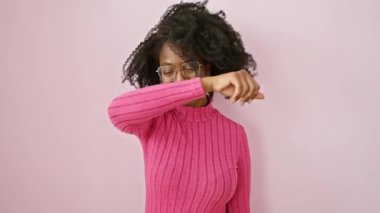 Neşeli Afrikalı Amerikalı kadın, gözlük takıyor, neşeli bir oyun oynuyor. Ayakta, gülümserken, elleri şen şakrak yüzünü gösteriyor..