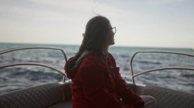 Polignano 'da kayıkla gezmekten hoşlanan genç bir İspanyol kadın bir kısrak, puglia, İtalya, deniz manzaralı ve arka planda kayalıklar var..