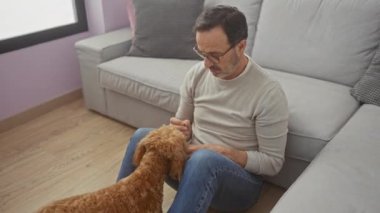 Orta yaşlı bir adam sıcak bir oturma odasında kanişiyle bağ kuruyor..