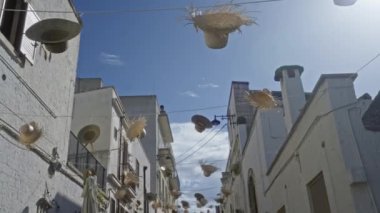 Alberobello, puglia, İtalya sokaklarının üzerinde asılı şenlikli şapkalar, berrak mavi bir gökyüzünün altında, bu güzel Avrupa kasabasında büyüleyici bir mimari sergiliyor..