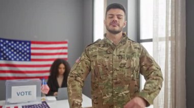 Kamuflajlı, kollarını kavuşturmuş bir asker, bir seçim merkezinde dikilirken, odaklanmış bir kadın dizüstü bilgisayarın arkasında oturuyor, hem de Amerikan bayrağıyla dolu bir odada..