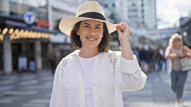 Stockholm sokaklarında kendinden emin gülümseyen genç, güzel İspanyol kadın.