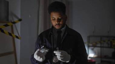 Yakışıklı Afro-Amerikan erkek dedektif olay yerindeki kanıtları inceliyor.