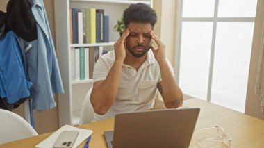 Stresli bir Afrikalı Amerikalı adam, sıradan bir ortamda düşünceli bir atmosfer yaratıyor.