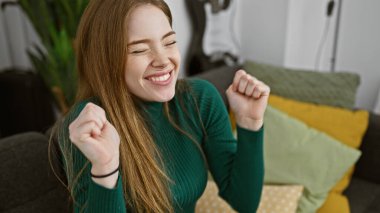 Oturma odasında gülen neşeli genç bir kadın..