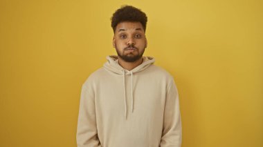 Sarı arka planda kapüşonlu yakışıklı Afro-Amerikan bir adamın portresi..