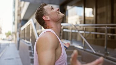 Şehir arka planında bulanık bir sokakta dikilen adam neşeyle gülüyor..