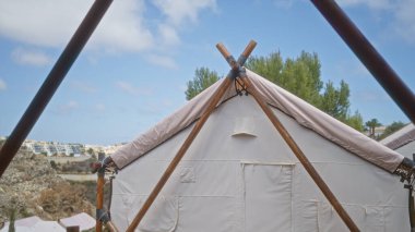 Afrika doğasında kamp macerası. Arka planda ağaçlar ve kayalar olan mavi gökyüzünün altında manzaralı bir çadır..