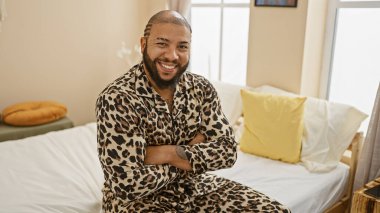 Sakallı Afrikalı Amerikalı bir adam evde pijamalarıyla poz veriyor..