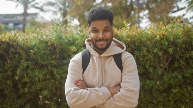 Doğada kollarını kavuşturmuş özgüvenli bir Afrikalı Amerikalı 'nın portresi..