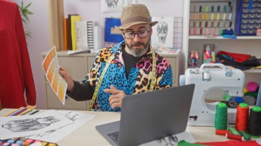 Şık bir adam canlı bir terzi dükkanındaki video görüşmesinde renk örneklerini inceliyor..