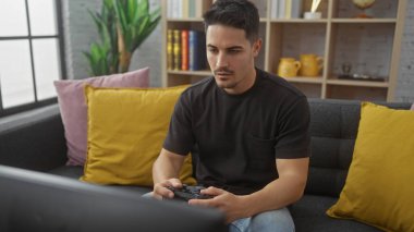 Modern bir oturma odasında video oyunu oynayan sakallı yakışıklı İspanyol bir adam..