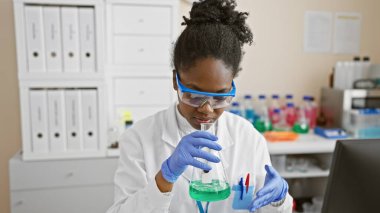 Laboratuvarda sıvı analizi yapan Afrikalı kadın bilim adamı.