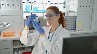 Kafkasyalı genç bir kadın laboratuvar ortamında matarayı inceliyor, profesyonelliği somutlaştırıyor ve odaklanıyor..