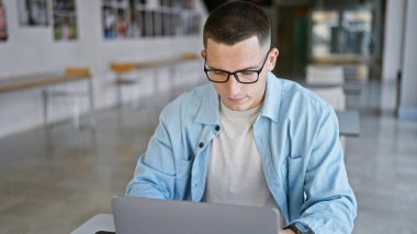 Üniversite kütüphanesinde dizüstü bilgisayar okuyan yakışıklı bir İspanyol..