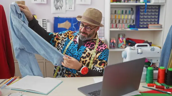 stock image A stylish man examines a garment in a vibrant tailor shop filled with sewing materials and colorful threads.