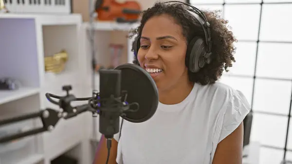 Stock image African american woman singing in music studio