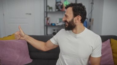 Beyaz tişörtlü, parlak orta yaşlı bir adam. Memleketinde gururlu bir gülümsemeyle başparmak kaldırıyor. Başarının resmine bakıyor.