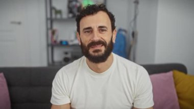Neşeli orta yaşlı bir adam evinde neşeli bir anın tadını çıkarıyor, beyaz bir tişört giyiyor, eli şakacı bir şekilde gözlerini örtüyor. Neşe dolu göz bağının sürprizi!
