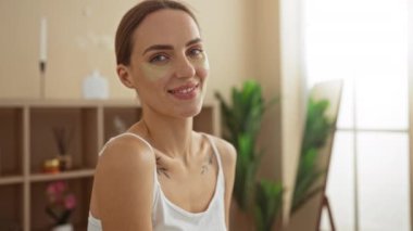 Sarışın, beyaz bir kadın, spa sağlık merkezinde, göz bantlarıyla, kapalı alanda gülümsüyor, güzellik ve rahatlama gösteriyor..