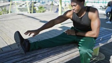 Genç bir Afrikalı Amerikalı, şehir merkezindeki bir bankta esniyor..