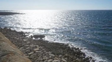 Puglia, İtalya 'daki Gelibolu' nun kıyı manzarası kayalık sahili ve parlak mavi gökyüzünün altında parıldayan, güneşli bir deniz dalgasını gösteriyor..