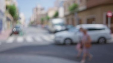 Bulanık şehir caddesi, kimliği belirsiz kişiler ve araçlarla güneşli bir gün, yaz ya da ilkbaharı öneren parlak şehir arkaplanı sağlar.