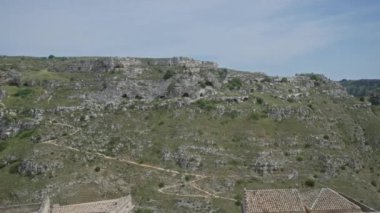 Materya, bazilika ve İtalya 'daki kayalık tepe manzaralarının muhteşem panoramik manzarası berrak mavi gökyüzü altında antik mağara evleri ile birlikte..