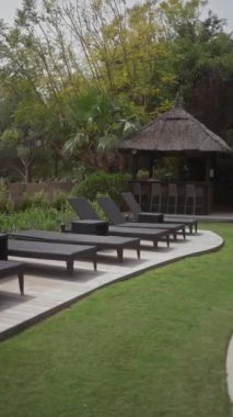 Güneşli yatakları, çardağı, manikürlü çimenleri, tropik bitkileri ve dolambaçlı bir yolu olan sakin bir tatil köyü..