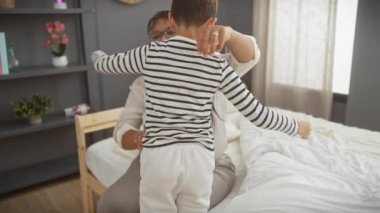 Sıcak bir yatak odasında, samimi bir anne ve oğul anını tasvir eden bir kadın ve çocuk sevgi dolu bir kucaklaşmayı paylaşıyorlar..