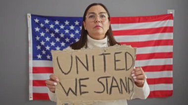 Olgun İspanyol kadın, bir ofis kurulumunda Amerikan bayrağının önünde 