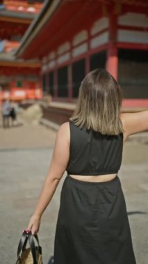 Kolları açık neşeli İspanyol bir kadın, Kyoto sokaklarında özgürlüğü kucaklıyor, kaygısız bir gülümseme çerçevelenmiş gözlükleriyle güzelliğini ödünç veriyor.